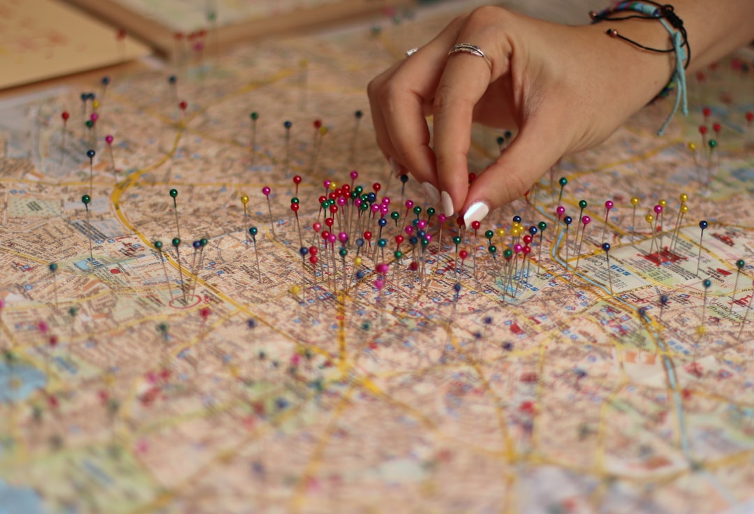 A hand placing pins on a printed map