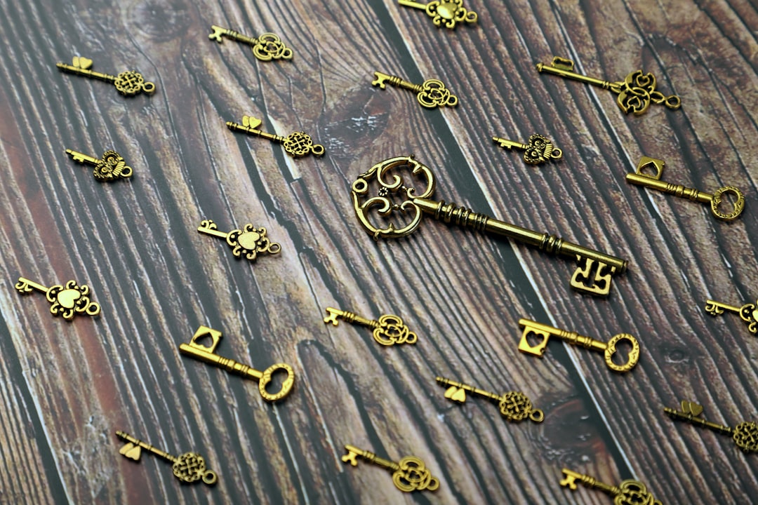A gold and silver skeleton key resting on a wooden surface