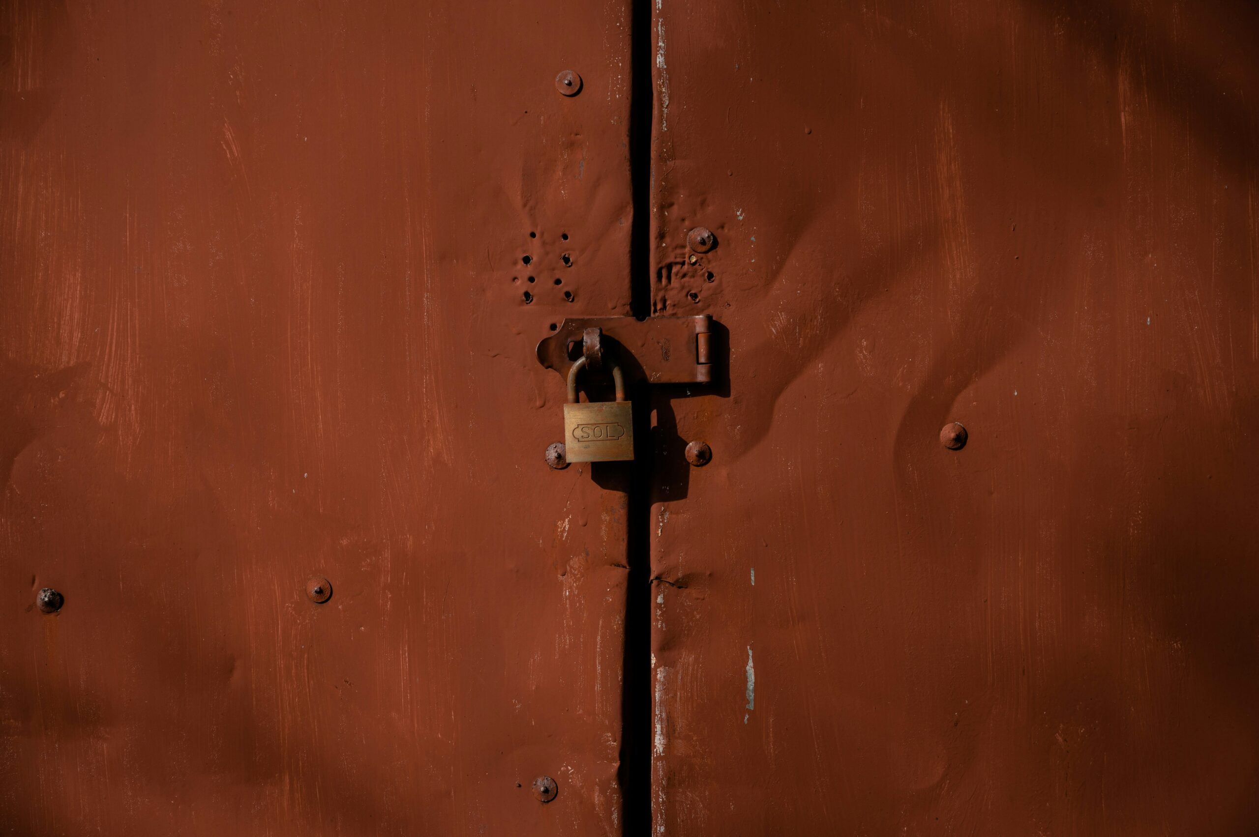 Orange and silver padlock on orange door