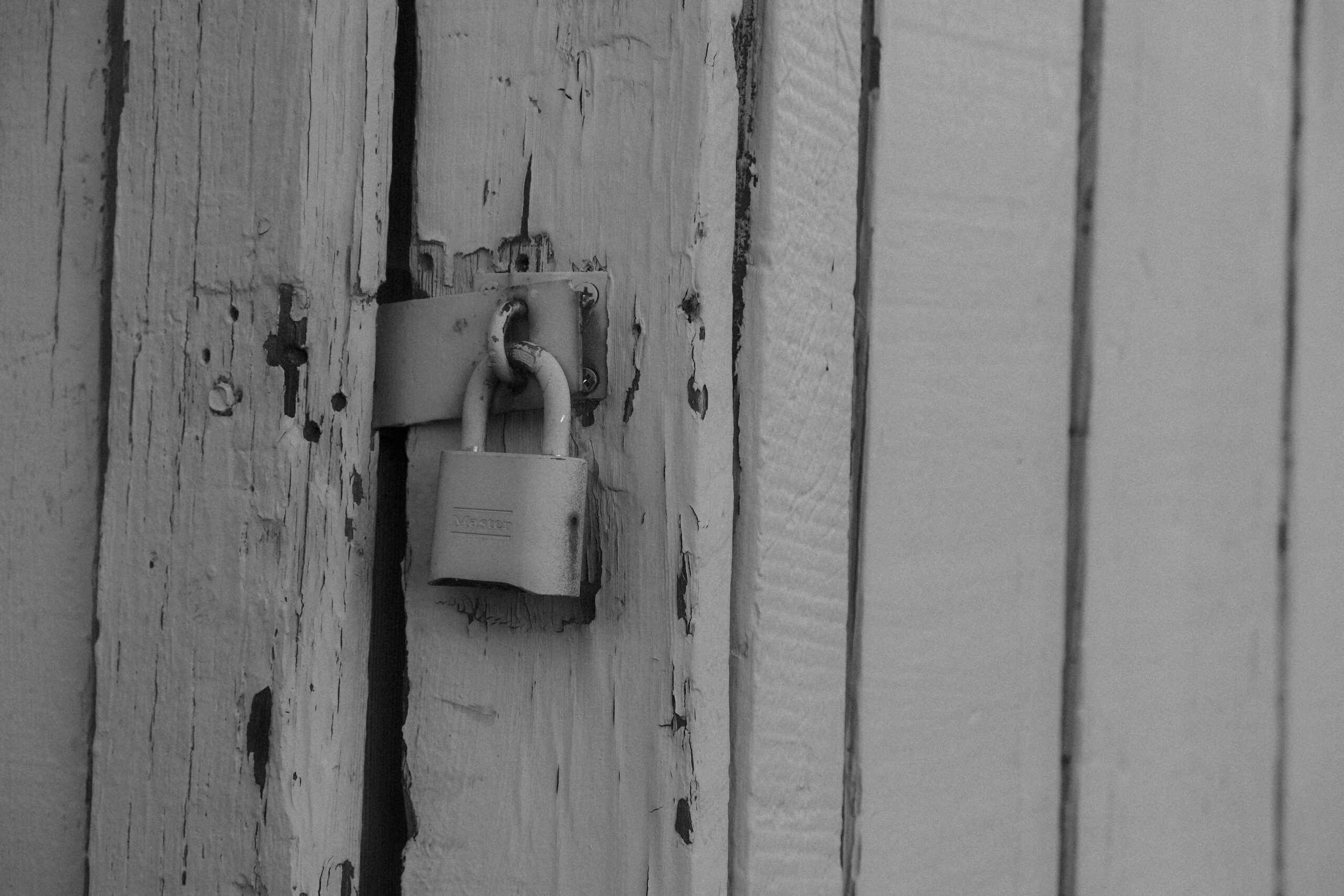 White padlock on white wooden door