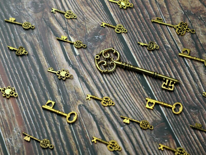 Silver and gold skeleton key on wooden surface
