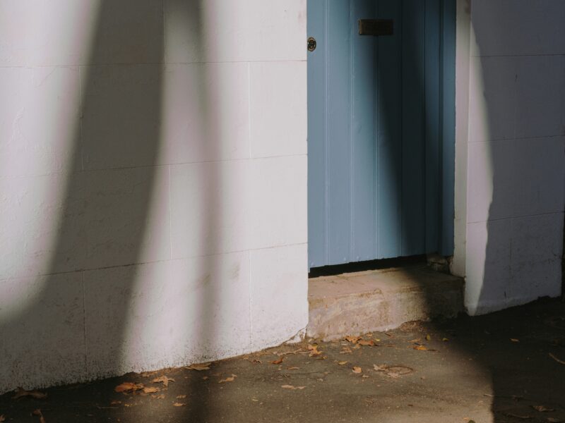 White concrete wall near black wooden door