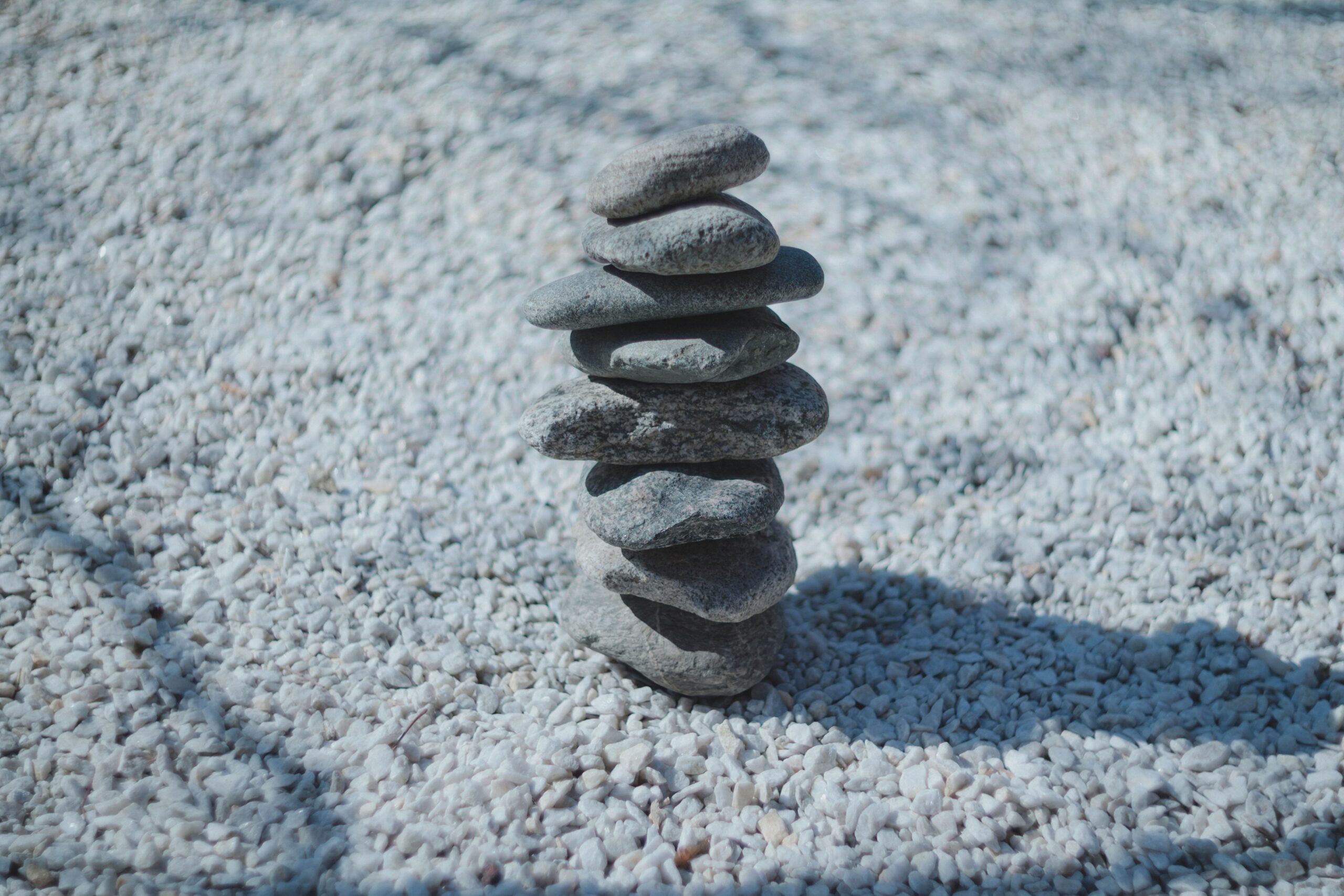 A stacked stone tower rests on white gravel.