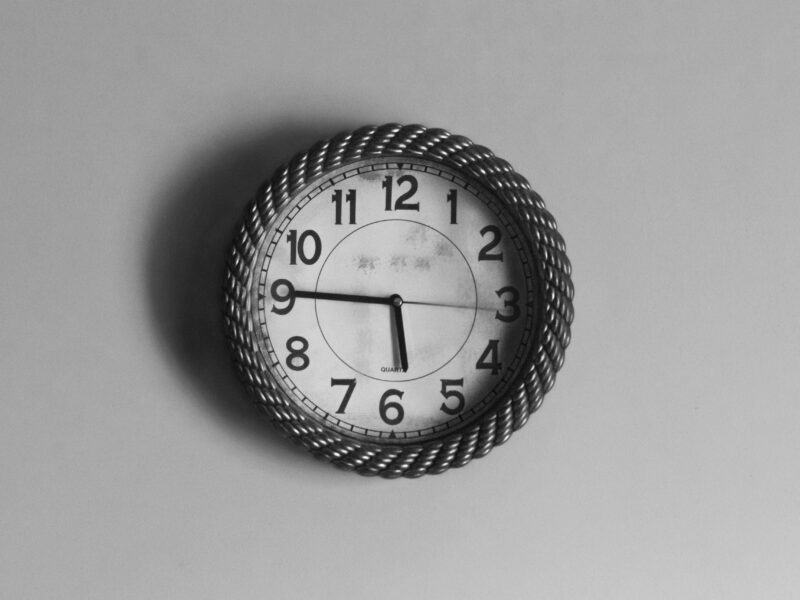 Black and white analog wall clock at 10 10
