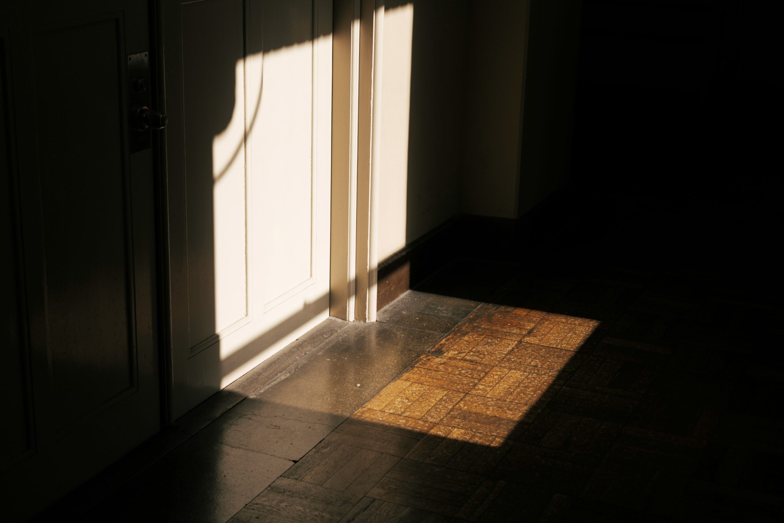 A door is open in a dark room